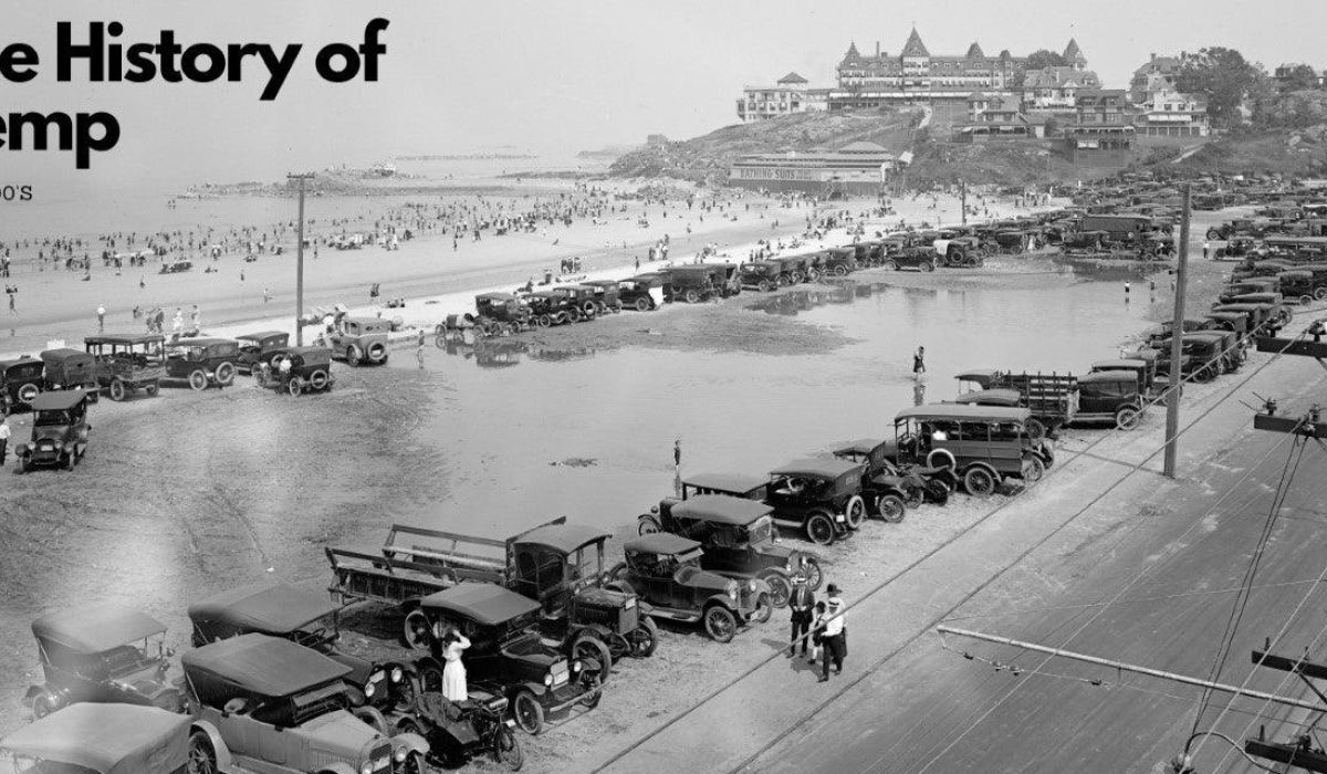 Black and white photo of 1900s cars parked by a busy beach, with crowds on the sand and buildings on a hill in the background. Text reads "The History of Hemp - The 1900s.